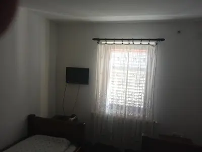 a bedroom with a bed and a window with curtains at Sobe Nevenka in Vrnjačka Banja