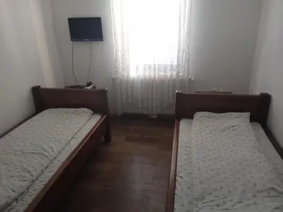 two beds in a small room with a window at Sobe Nevenka in Vrnjačka Banja