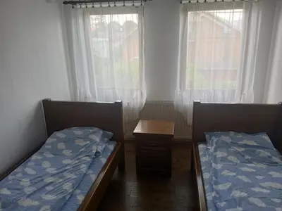 two beds in a room with two windows at Sobe Nevenka in Vrnjačka Banja