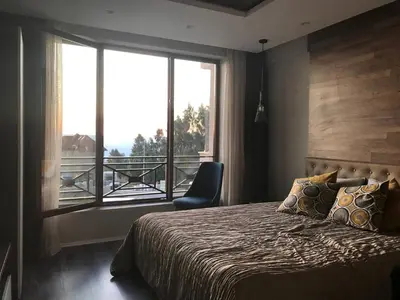 a bedroom with a bed and a large window at Premier 24 Milmari Kopaonik in Kopaonik
