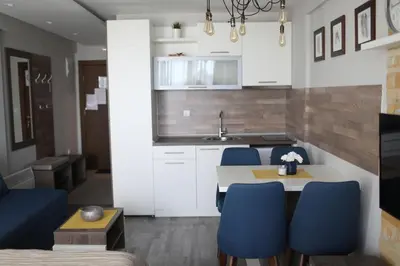 a kitchen with a table and blue chairs at Premier 24 Milmari Kopaonik in Kopaonik