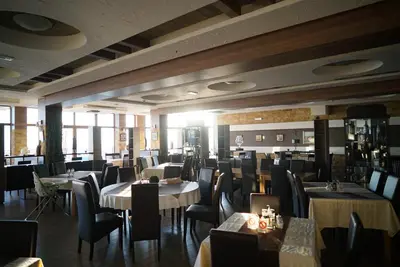 a restaurant with tables and chairs in a room at Premier 24 Milmari Kopaonik in Kopaonik