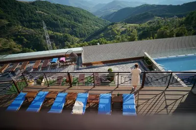a man standing on a deck looking at the mountains at Premier 24 Milmari Kopaonik in Kopaonik