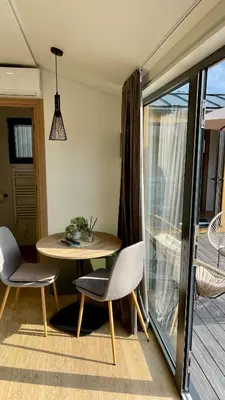 a small table and chairs in a room with a balcony at Kapija Svrljiga in Svrljig