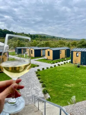 a person holding a glass of wine looking at a row of tiny houses at Kapija Svrljiga in Svrljig