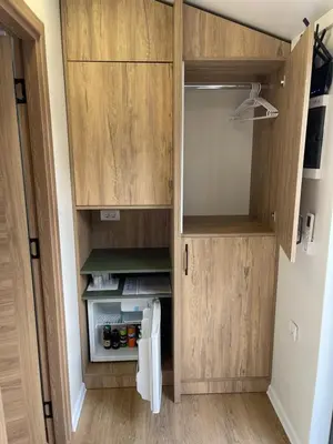 a small kitchen with wooden cabinets and a refrigerator at Kapija Svrljiga in Svrljig