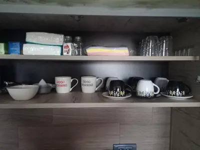 a shelf with three coffee cups and other items at Šilja Kopaonik S45 Milmari in Kopaonik