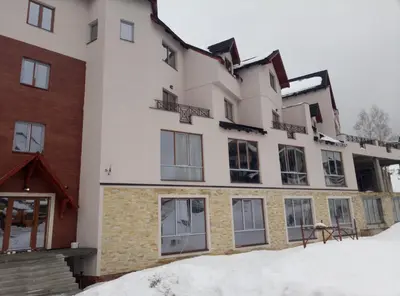 an apartment building with snow in the foreground at Šilja Kopaonik S45 Milmari in Kopaonik