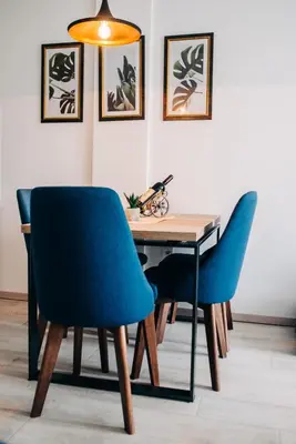 a dining room table with two blue chairs and a desk at Šilja Kopaonik S45 Milmari in Kopaonik