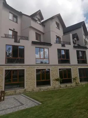 a large white building with windows and a lawn at Šilja Kopaonik S45 Milmari in Kopaonik