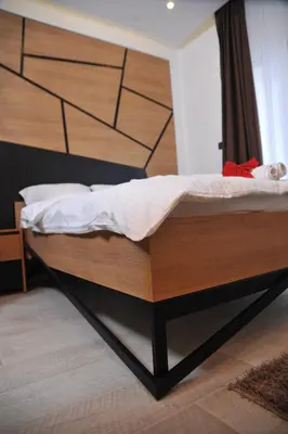 a bed with a wooden headboard in a room at Milmari boutique S3 lux in Kopaonik
