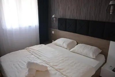 a bedroom with a white bed with two towels on it at Amor in Vrnjačka Banja