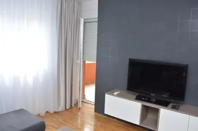 a living room with a flat screen tv on a stand at Amor in Vrnjačka Banja