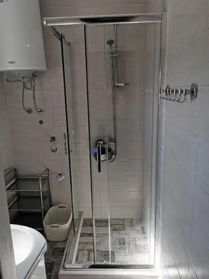 a shower with a glass door in a bathroom at Radman's house in Niš