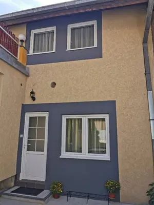 a house with a blue door and two windows at Radman's house in Niš