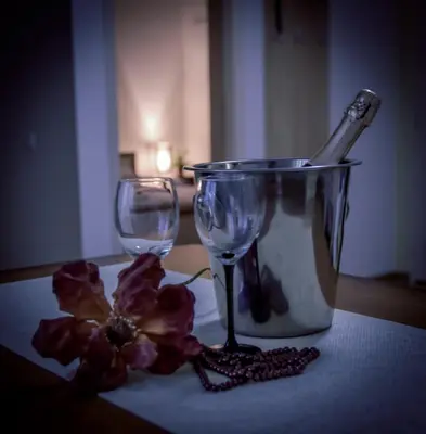 a couple of wine glasses and a flower on a table at Radman's house in Niš