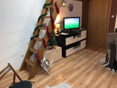 a living room with a staircase with a television at Apartman Planinski raj in Kopaonik