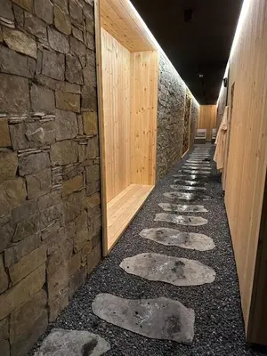a hallway with a stone wall and stepping stones at Apartman Planinski raj in Kopaonik