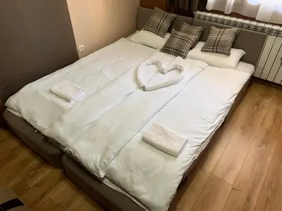 a large bed with two towels in the shape of a heart at Apartman Planinski raj in Kopaonik