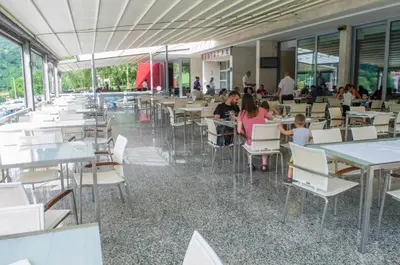 a group of people sitting at tables in a restaurant at Motel Predejane in Predejane