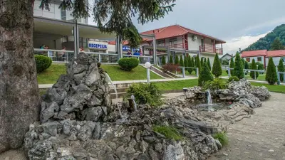 a fake rock fountain in front of a building at Motel Predejane in Predejane