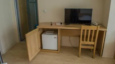 a desk with a television and a chair in a room at Motel Predejane in Predejane