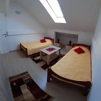 a room with two beds and a table in it at BC Apartments in Niš