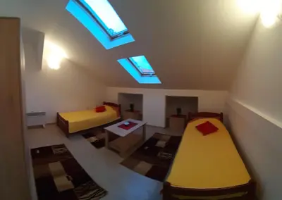 a attic room with two beds and a skylight at BC Apartments in Niš