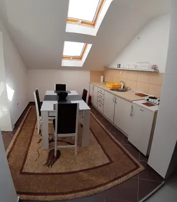 a kitchen with a table and chairs in a room at BC Apartments in Niš