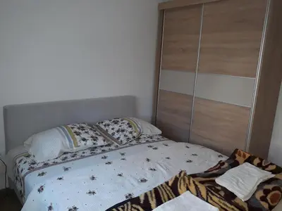 a bedroom with a bed and a wooden closet at Iznad Oblaka1 Apartment PA-JO in Kopaonik