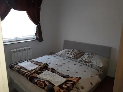 a bed with blankets and pillows on it in a bedroom at Iznad Oblaka1 Apartment PA-JO in Kopaonik