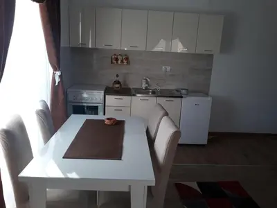 a kitchen with a white table with chairs and a sink at Iznad Oblaka1 Apartment PA-JO in Kopaonik