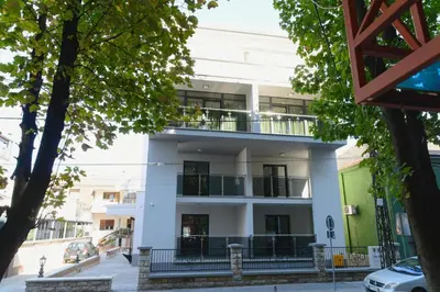 a white building with a balcony on a street at VIR Villa in Kruševac
