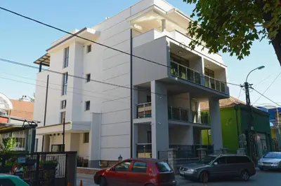 a white building with cars parked in front of it at VIR Villa in Kruševac