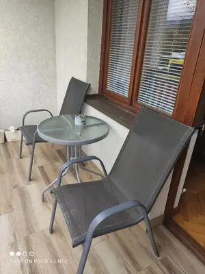 two chairs and a table in a room with a window at Vila Čair DOPLATA ZA BAZEN in Soko Banja
