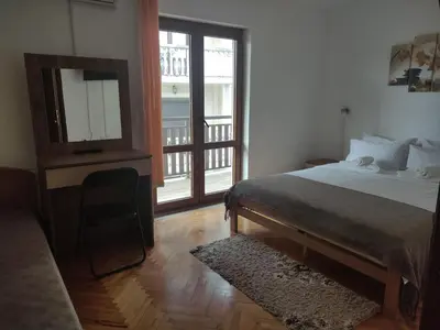 a bedroom with a bed and a mirror and a television at Vila Čair DOPLATA ZA BAZEN in Soko Banja