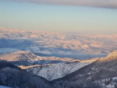 a view of a snowy mountain range with a lake at Apartment S&A Milmari Resort S43 in Kopaonik