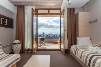 a hotel room with two beds and a balcony at Milmari Resort & Spa Suites in Kopaonik