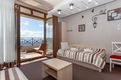 a bedroom with a bed and a balcony at Milmari Resort & Spa Suites in Kopaonik