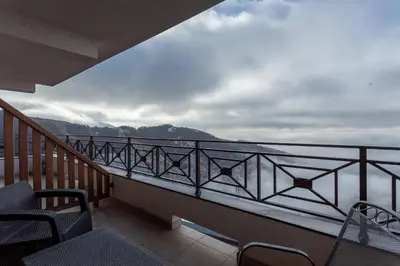a balcony with chairs and a view of the water at Milmari Resort & Spa Suites in Kopaonik