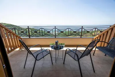 a patio with two chairs and a table on a balcony at Milmari Resort & Spa Suites in Kopaonik