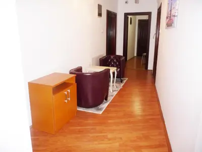 a living room with a table and chairs and a floor at Sobe Rooms Aleksandar in Niš