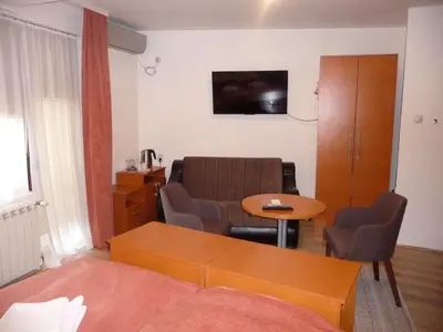 a living room with a couch and a table at Sobe Rooms Aleksandar in Niš
