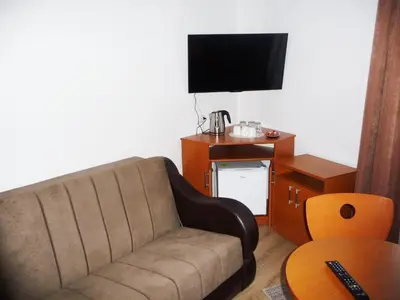 a living room with a couch and a tv at Sobe Rooms Aleksandar in Niš