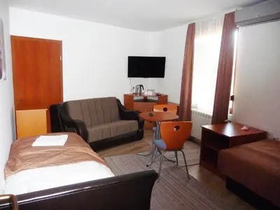 a hotel room with a bed and a couch at Sobe Rooms Aleksandar in Niš