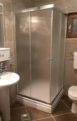 a shower in a bathroom with a sink and a toilet at Sunrise apartmani in Kopaonik