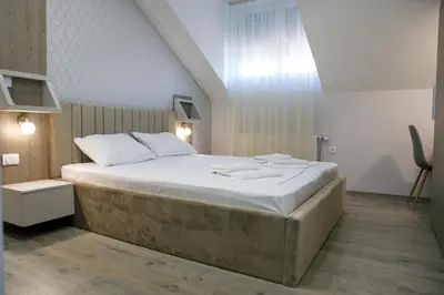 a bedroom with a large bed with white sheets at Fine Suites in Niš