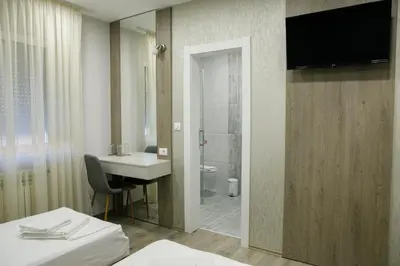 a bathroom with a sink and a toilet and a television at Fine Suites in Niš