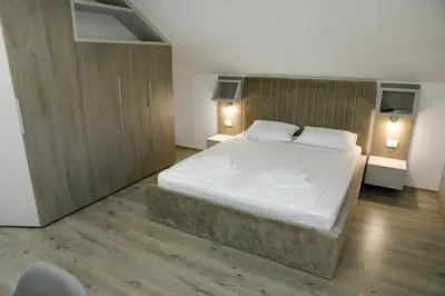 a bedroom with a large bed and two night stands at Fine Suites in Niš