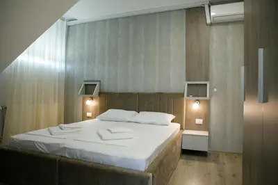a bedroom with a bed with two towels on it at Fine Suites in Niš